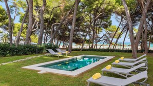 Un espace piscine avec des chaises longues et vue sur la mer.