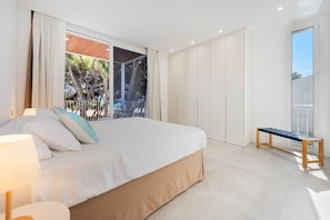 Une chambre à coucher avec un lit, un banc et une vue sur l’extérieur.