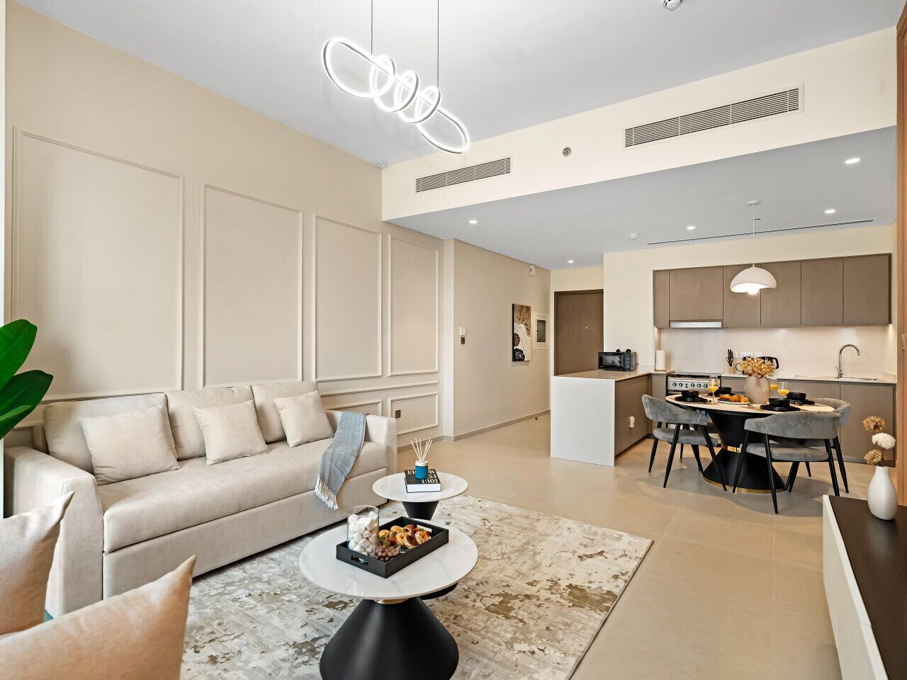 Een moderne woonkamer met een bank, salontafel en een eetgedeelte met stoelen.