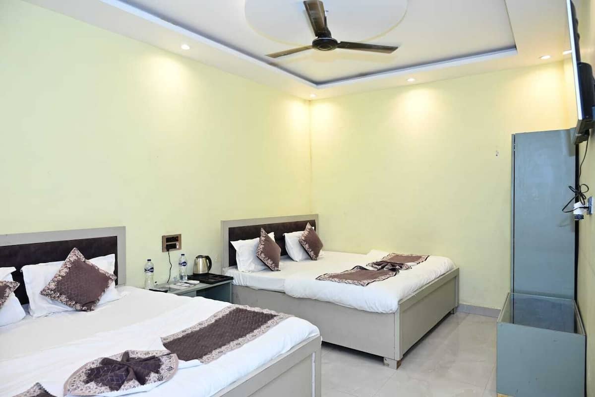 A hotel room with two beds, a ceiling fan, and a minibar.