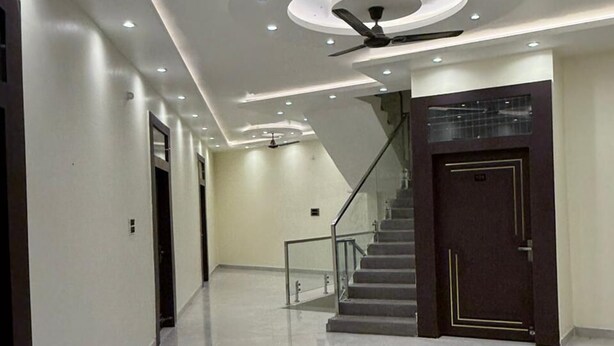 A modern hallway with a polished marble floor, a staircase, and recessed ceiling lighting. - Hotel Ramarsh Palace (Ayodhya)