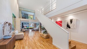 A spacious interior with a staircase, wooden flooring, and modern furnishings. - Villa Ocean - Beachfront Villa, Pool & Sea Views (Port d'Alcudia)