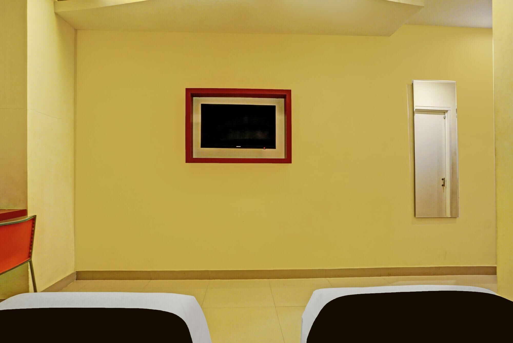A room with two beds, a framed picture on the wall, and a door.