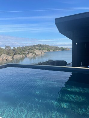 Ein Pool mit Blick auf eine natürliche Landschaft und ein Gebäudebau.