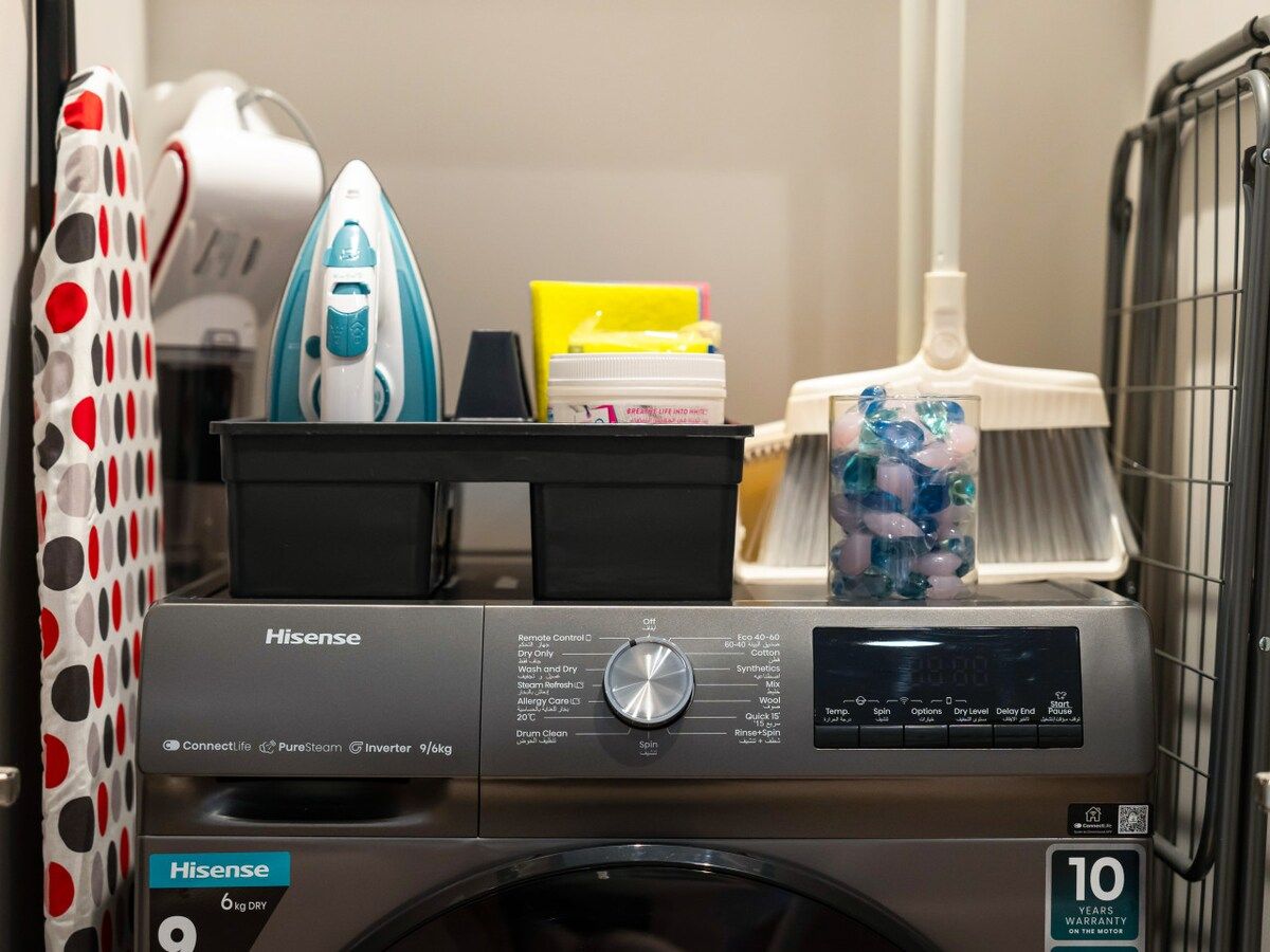 Een Hisense wasmachine met 10 jaar garantie, een droogrek en een wasmand.