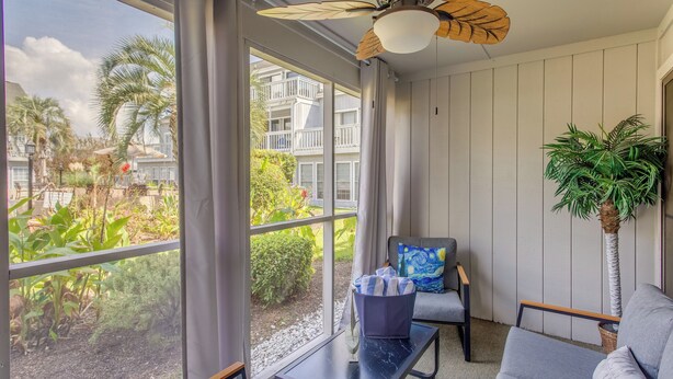 A room with a large window, a ceiling fan, a gray sofa, a small table, and a potted plant. - 4 Mi to Beach: Unit w/ Pool Access in Little River (Little River)