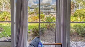 A room with a large window overlooking a landscaped garden and a building with a balcony. - 4 Mi to Beach: Unit w/ Pool Access in Little River (Little River)