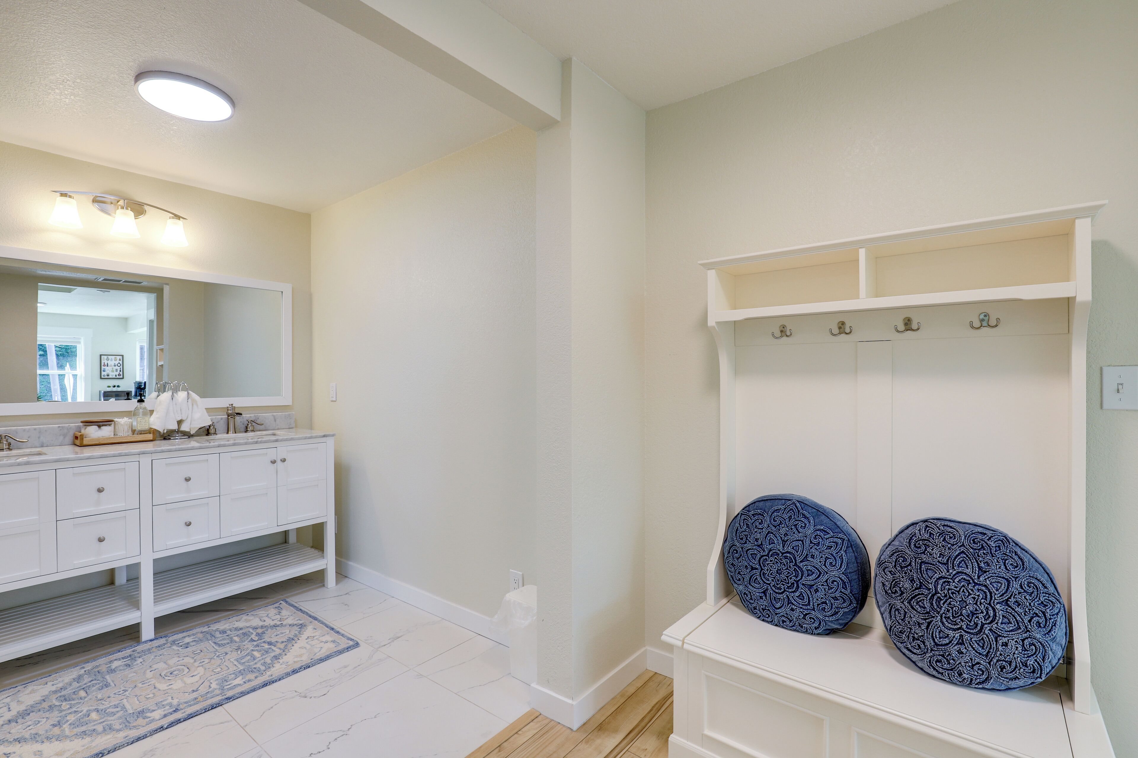 A bathroom with a white vanity, a mirror, and a blue patterned towel holder.