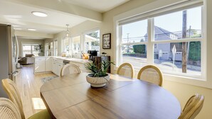 A spacious kitchen with a dining area, large windows, and a view of the outside. - Walk to Dtwn Camas! Updated Home w/ Game Room (Camas)