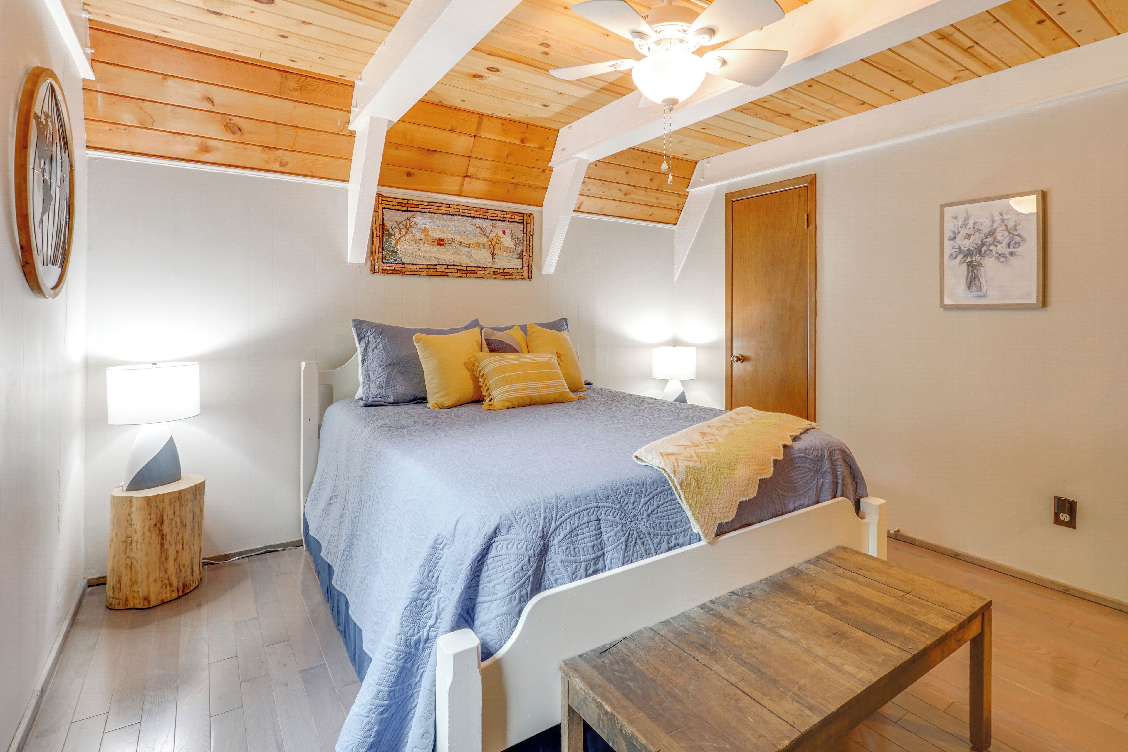 Ein Schlafzimmer mit Bett, Nachttisch und Deckenventilator.