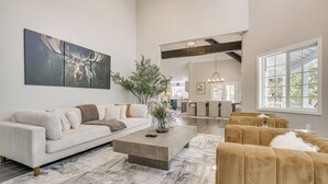 A spacious living room with a large painting, a coffee table, and a sofa.