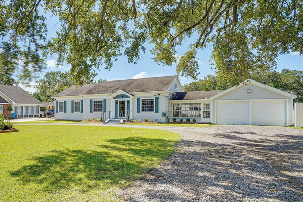 A two-story house with a front porch, a garage, and a well-maintained lawn. - Sunshine Under the Oak: Baldwin Home w/ Patio! (Baldwin)