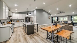 A spacious kitchen with white cabinets, a central island, and pendant lighting. - Private Beach on Lake Barkley! Scenic Family Oasis (Cadiz)