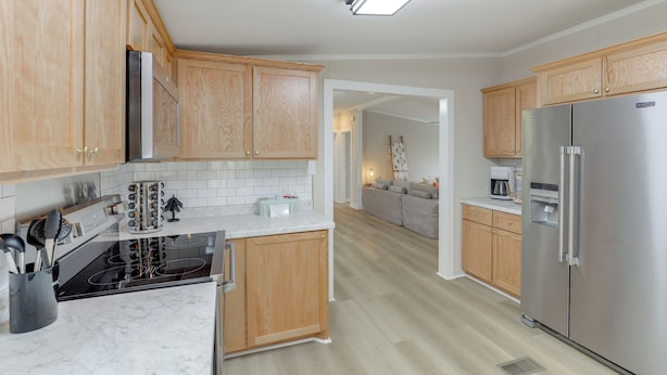 A modern kitchen with wooden cabinets, stainless steel appliances, and a marble countertop. - Deck w/ Mtn Views: Family-friendly Asheville Home! (Asheville)