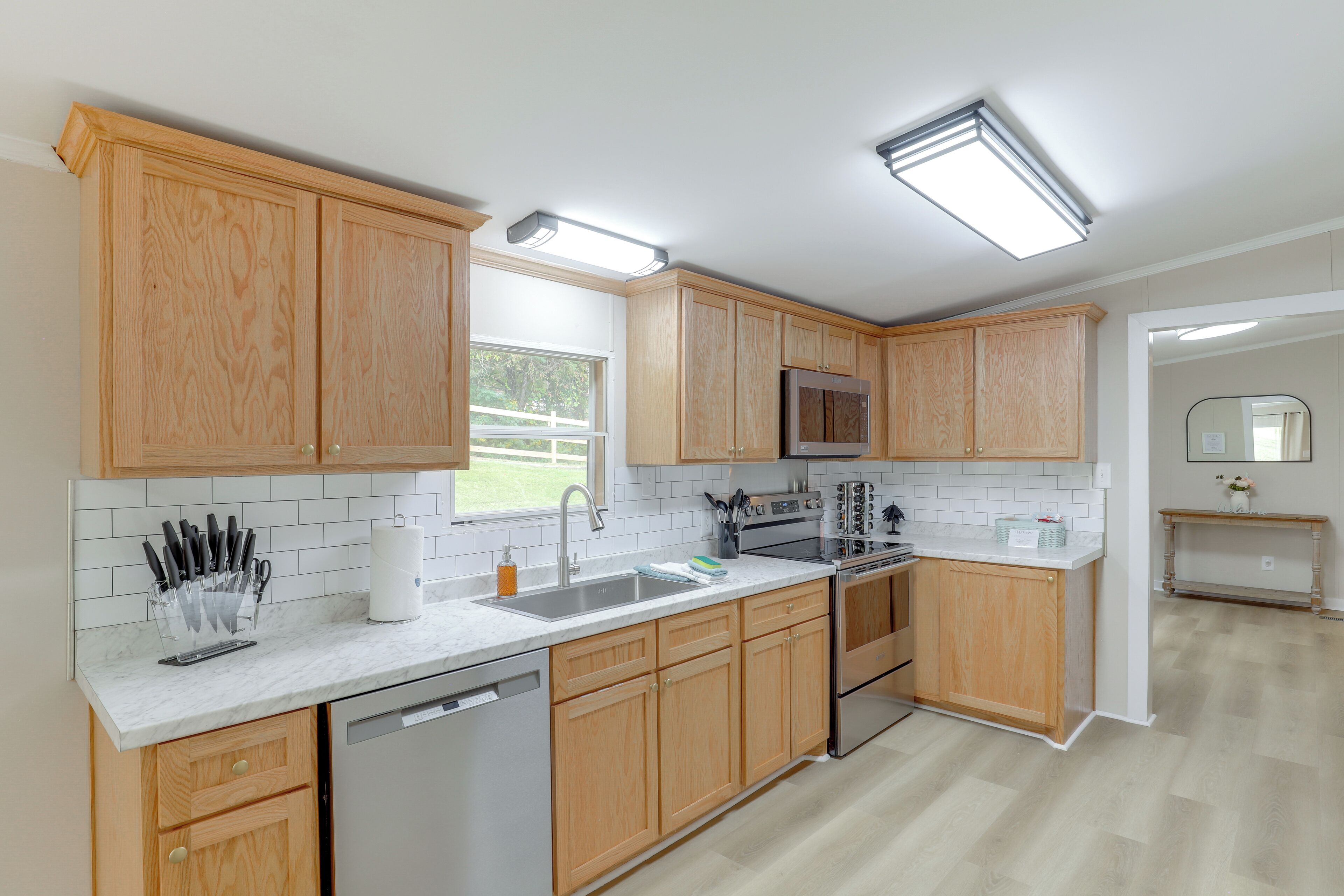 Una cocina moderna con armarios de madera, un refrigerador de acero inoxidable y un lavavajillas.