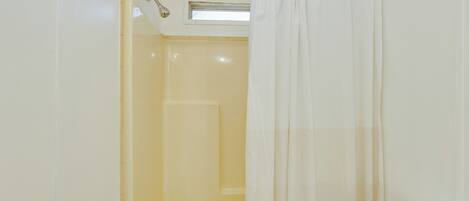 Un baño con bañera, inodoro y cortina de ducha.