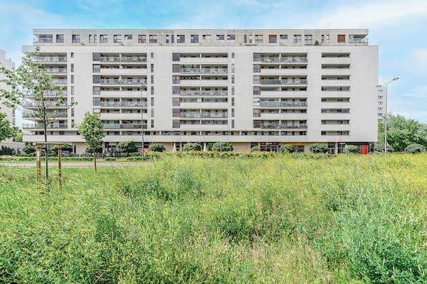 A multi-story residential building with balconies, a flat roof, and a central courtyard. - Aleja Komisji Edukacji Narodowej (Warsaw)