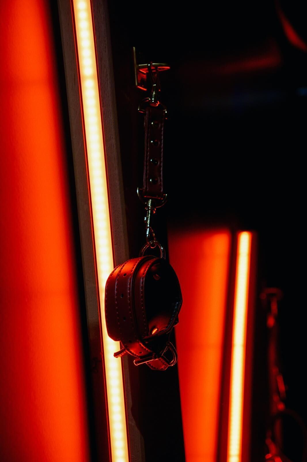 Um close-up de uma correia de couro pendurada em uma peça de metal, provavelmente parte de um equipamento ou móvel.