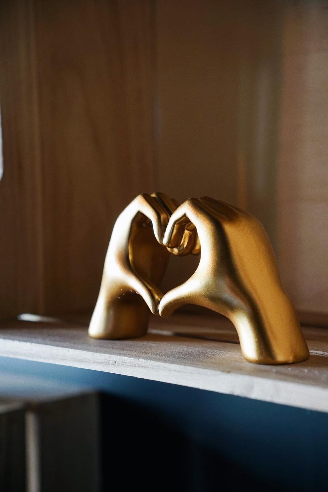 A golden heart-shaped object on a shelf.