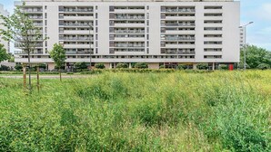 A multi-story residential building with balconies, a flat roof, and a central courtyard. - P&O Apartments KEN (Warsaw)