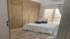 Un dormitorio con una cama, un armario de madera y una ventana.