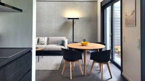 Une cuisine moderne avec un coin repas, un canapé et une lampe sur pied.
