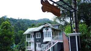 A two-story building with a balcony, a staircase, and a sign that reads "Nature Harmony." - Nature Harmony (Udumbanchola)
