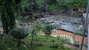 A natural landscape with a river, rocks, and greenery. - Nature Harmony (Udumbanchola)