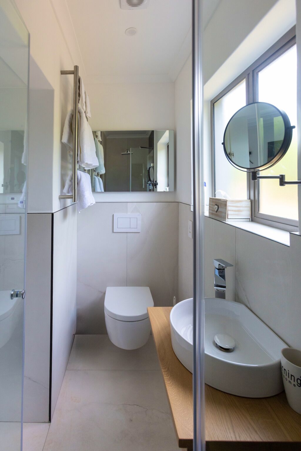 Une petite salle de bain comprenant des toilettes, un lavabo et un miroir.