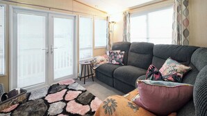A cozy living room with a sofa, a patterned rug, and a small table. - Host & Stay | Leon's Retreat (Cresswell)