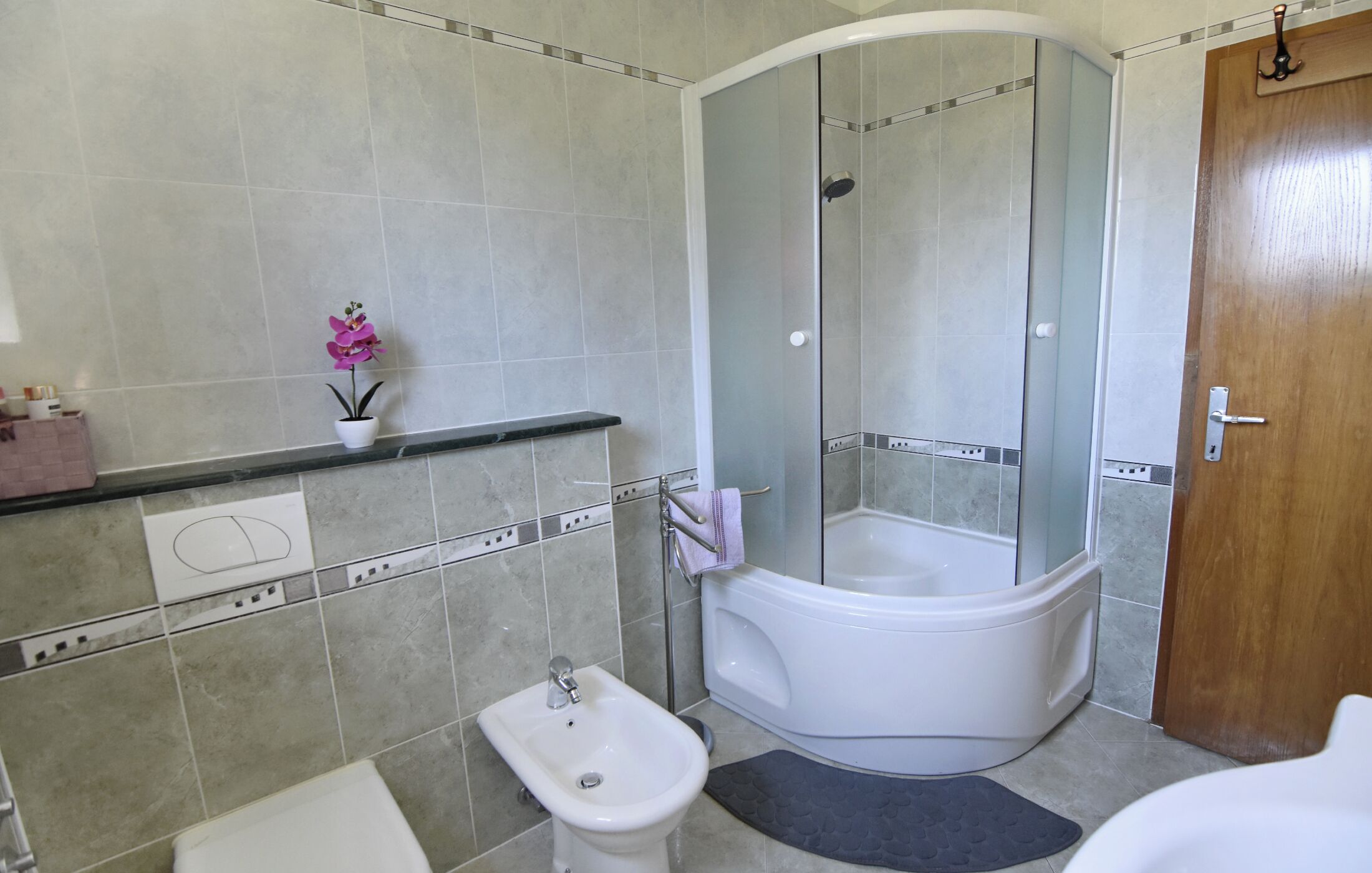 Un baño con ducha, bañera, lavabo e inodoro.