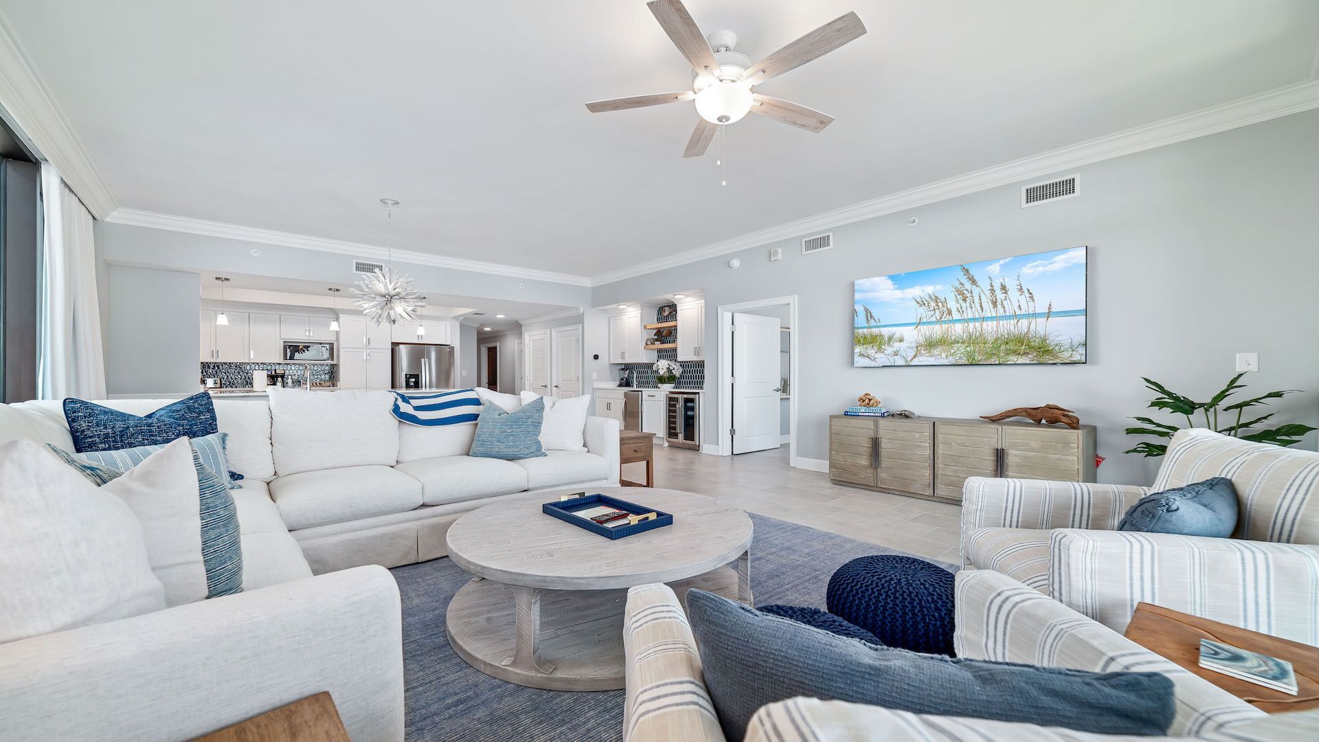 A spacious living room with a white sofa, a round coffee table, and a ceiling fan.
