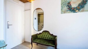 A room with a green upholstered bench, a white door, and a mirror on the wall. - Duomo Studio Room with Private Bath and Kitchenette (Firenze)