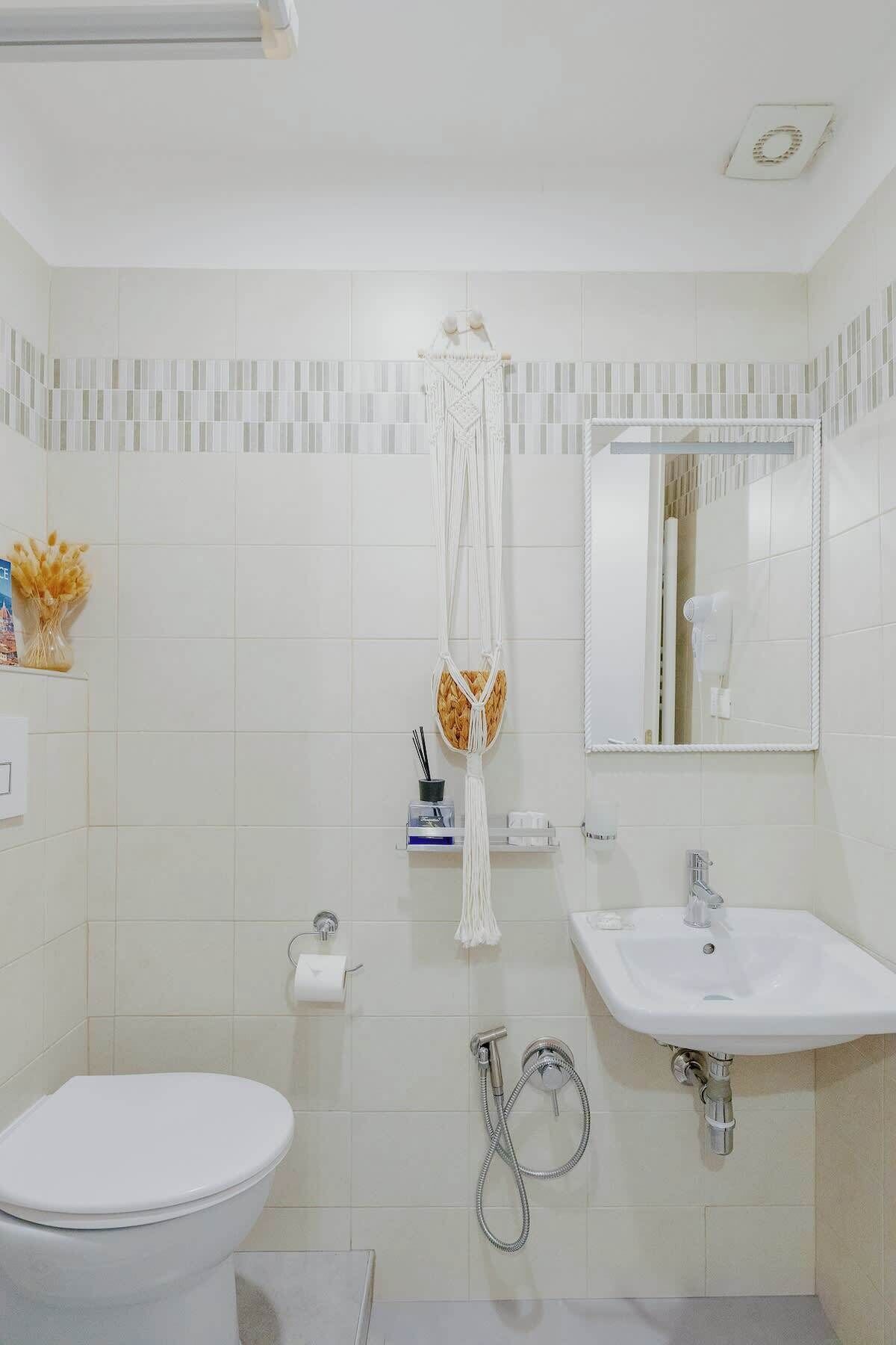 Ein Badezimmer mit Toilette, Waschbecken, Dusche und Handtuchhalter.