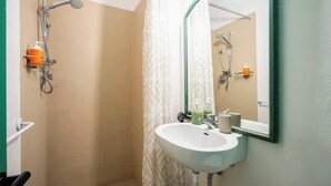 Une salle de bain avec une douche, un lavabo et un miroir.