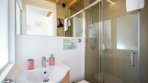 A bathroom with a white sink, a mirror, a glass shower enclosure, and a toilet. - Private Duomo Room with Ensuite Bath (Firenze)