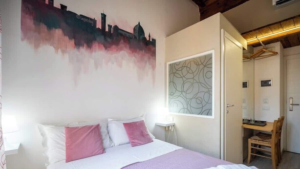 A hotel room with a bed, a desk, and a chair. - Private Duomo Room with Ensuite Bath (Firenze)