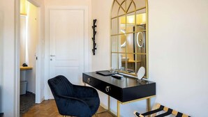 A modern room with a black vanity, a gold-framed mirror, and a black chair. - Central Florence Room w/ Wi-Fi & Pvt Bath (Firenze)