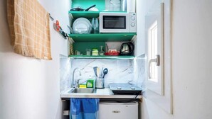 Une cuisine compacte équipée d’un four à micro-ondes, d’un évier et d’un petit réfrigérateur.