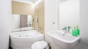 A modern bathroom with a bathtub, a sink, and a mirror.