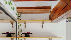 A room with wooden beams, a mirrored wall, and a wooden table.