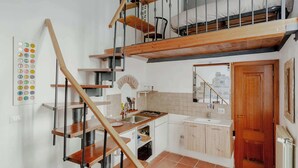 A kitchen with wooden shelves, a sink, and a stove.