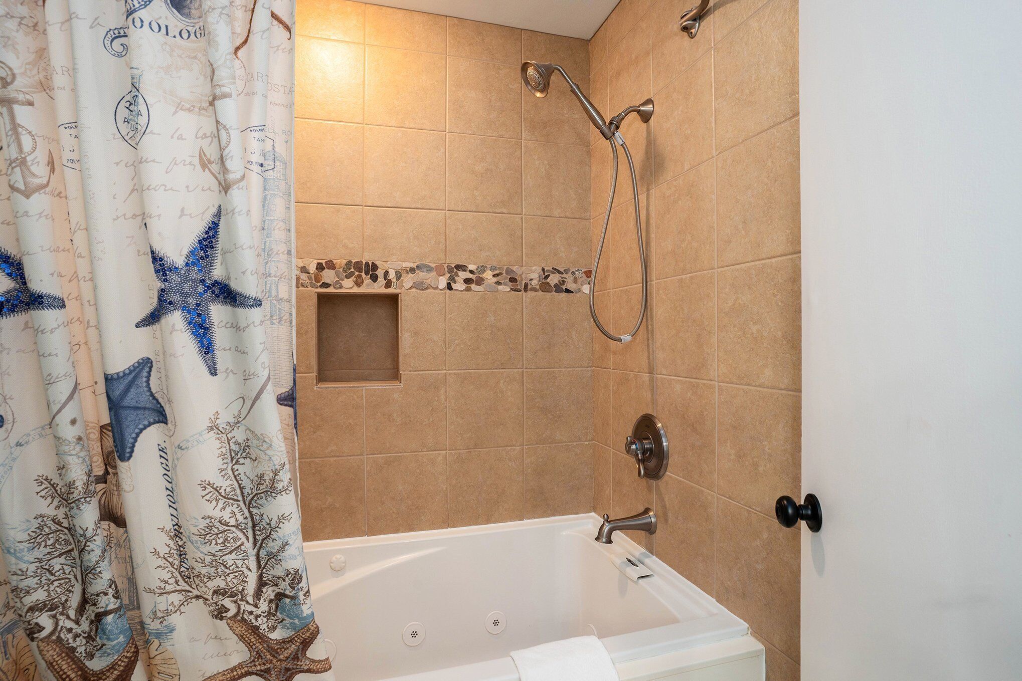 Ein Badezimmer mit Badewanne, Dusche und Fliesenwand.