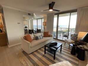 Ein modernes Wohnzimmer mit Sofa, Couchtisch und Blick auf den Balkon.