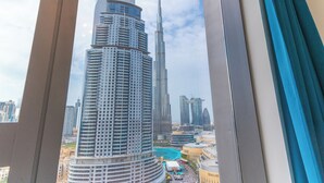 Vista del Burj Khalifa y edificios circundantes desde el interior de un edificio, con un marco de ventana visible en primer plano.