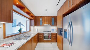 Una cocina moderna con armarios de madera, electrodomésticos de acero inoxidable y encimera de mármol.