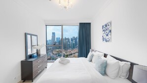 Habitación de hotel moderna con una cama grande, un aparador y vistas a la ciudad a través de la ventana.