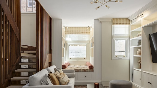 A cozy living room with a staircase, built-in bookshelves, a television, and a window with a view. - Charming Family Retreat – 4BR Marylebone (Greater London)