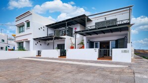 A modern building with a flat roof, a balcony, and a sign that reads "Calle El Charco." - El Charcón B • 10 meters to the beach • LVH (Arrieta)