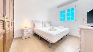 A hotel room with a bed, a nightstand, a dresser, and a window with blinds. - El Charcón B • 10 meters to the beach • LVH (Arrieta)